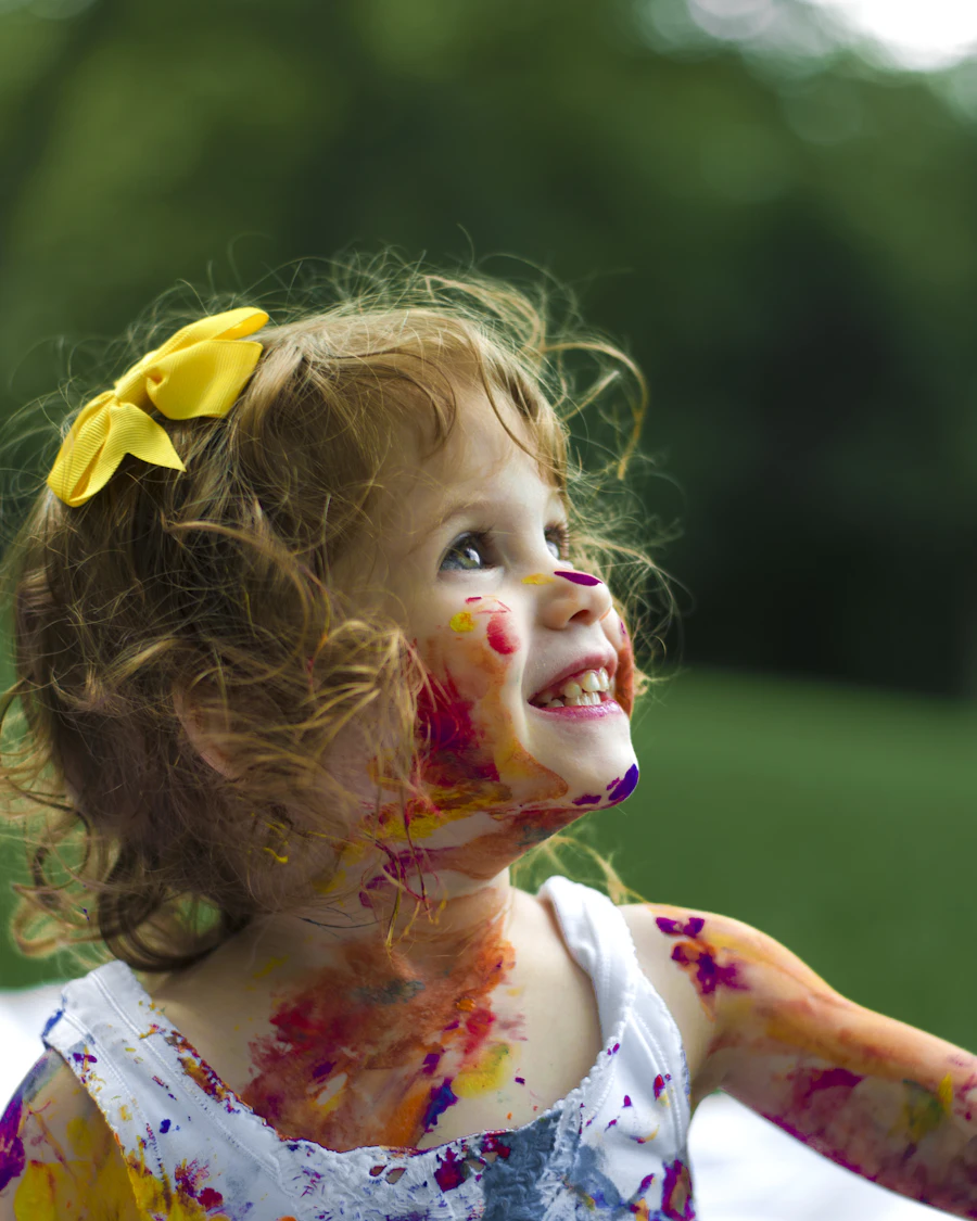 Niña sonriendo con la cara manchada de pintura